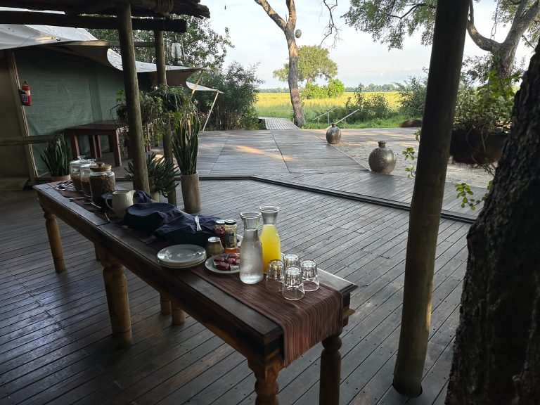 Botswana safari: breakfast table on camp deck at dawn