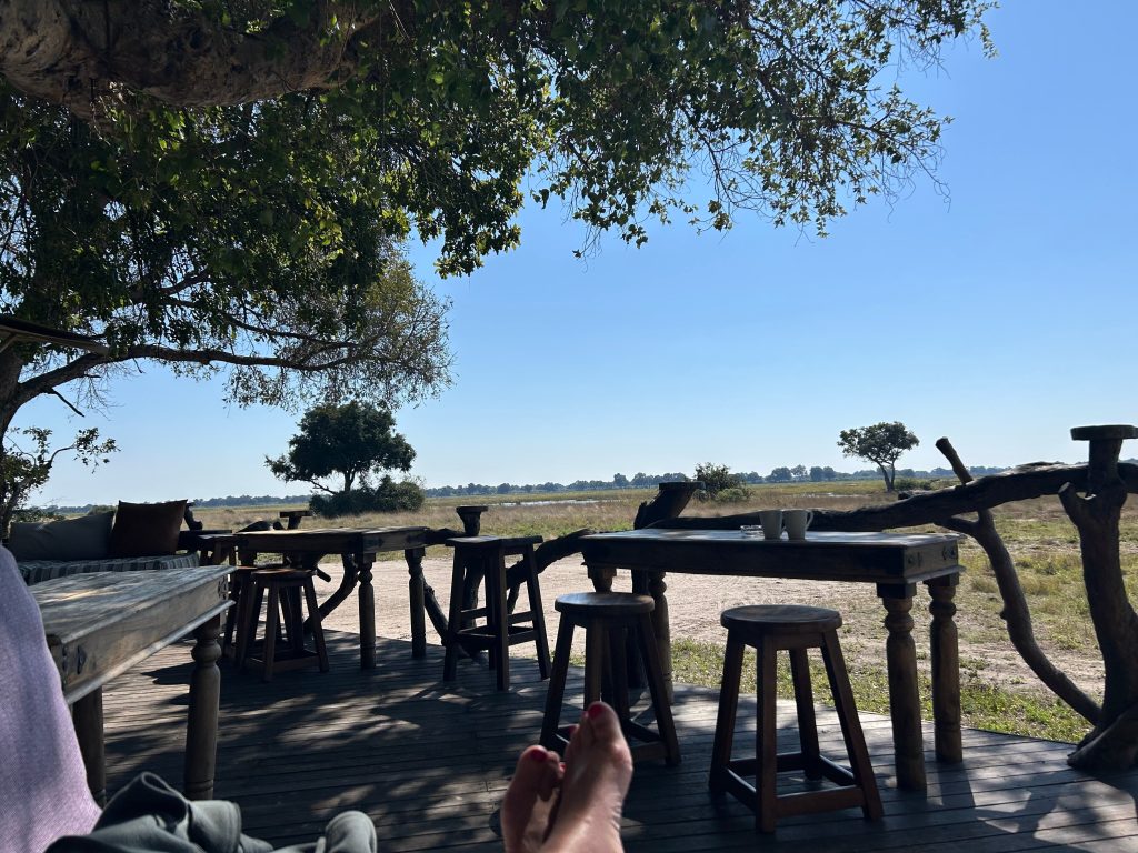 Botswana safari: camp deck with wooden tables overlooking floodplain