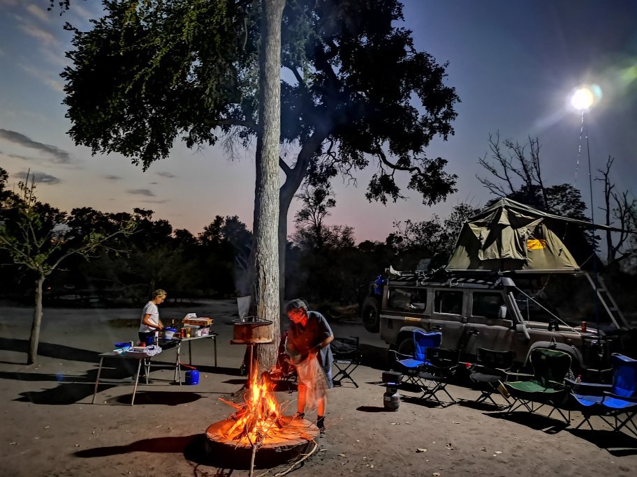 Botswana safari: campfire and rooftop tent camp at dusk