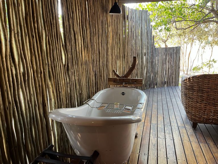 Botswana safari: outdoor bathtub on deck behind reed screen