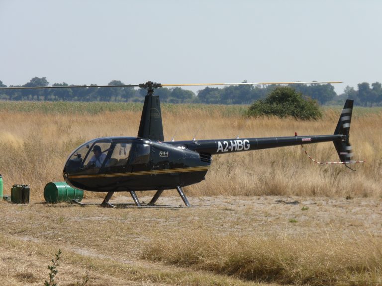Botswana safari: Robinson R44 helicopter parked on bush airstrip