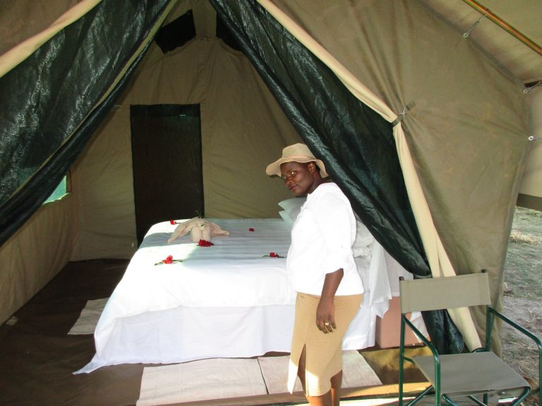 Botswana safari: woman beside made bed in safari tent